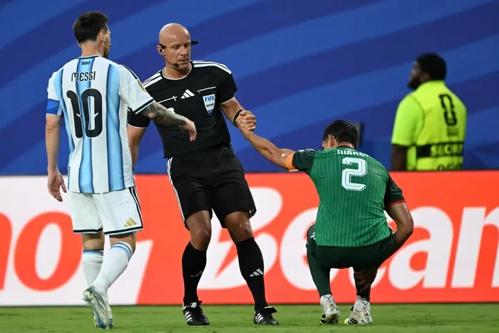 Polish referee Szymon Marciniak lifts Algeria's defender #02 Aissa Mandi as he reacts in pain next to Argentina's forward #10 Lionel Messi during the 2026 World Cup Group J football match between Argentina and Algeria at the Kansas City Stadium in Kansas City on June 16, 2026. Picture: ROBERTO SCHMIDT / AFP