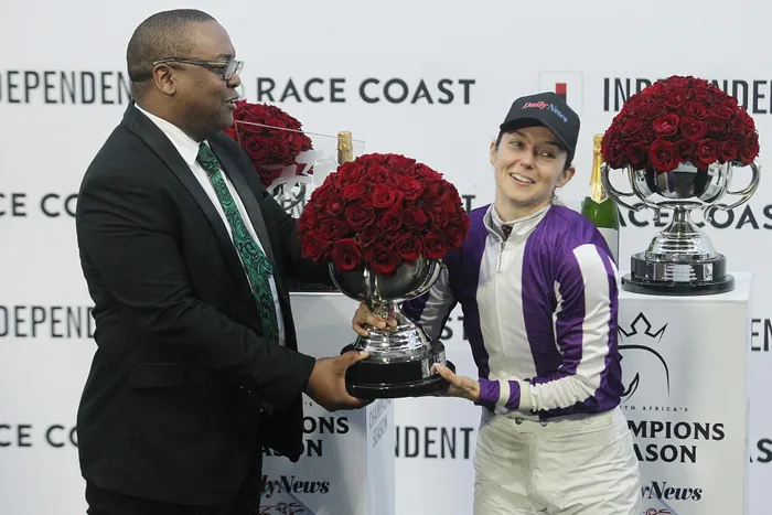 Daily News editor Ayanda Mdluli makes a presentation to the winning jockey Mickalle Michel.