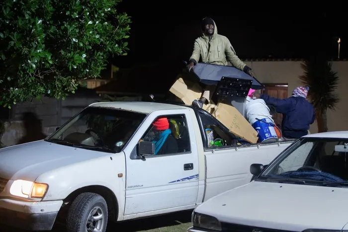 Immigrants arrive with their belongings at a community hall to take refuge in Gansbaai, about 140km from Cape Town, on June 2, 2026, after they were threatened in the communities in which they live.