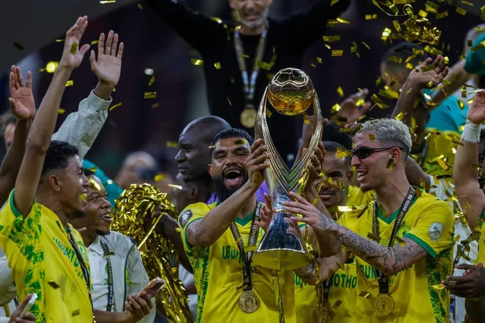 Mamelodi Sundowns' Keanu Cupido holds aloft the CAF Champions League trophy after his heroic performance in the second-leg final in Rabat on Sunday evening.