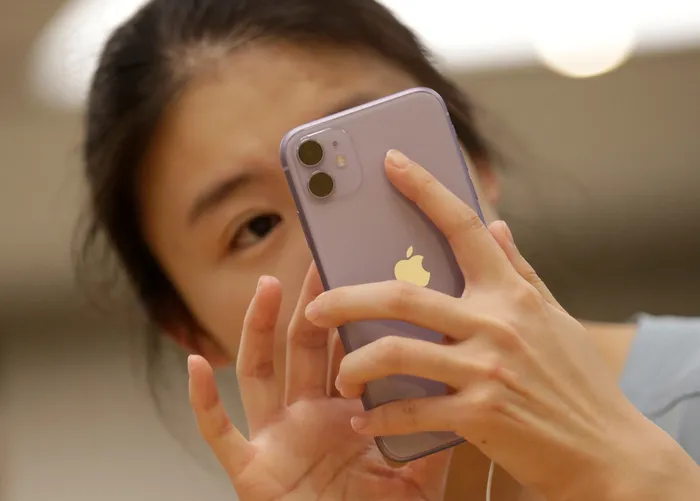 FILE PHOTO: A customer tests Apple's iPhone 11 after it went on sale at the Apple Store in Beijing