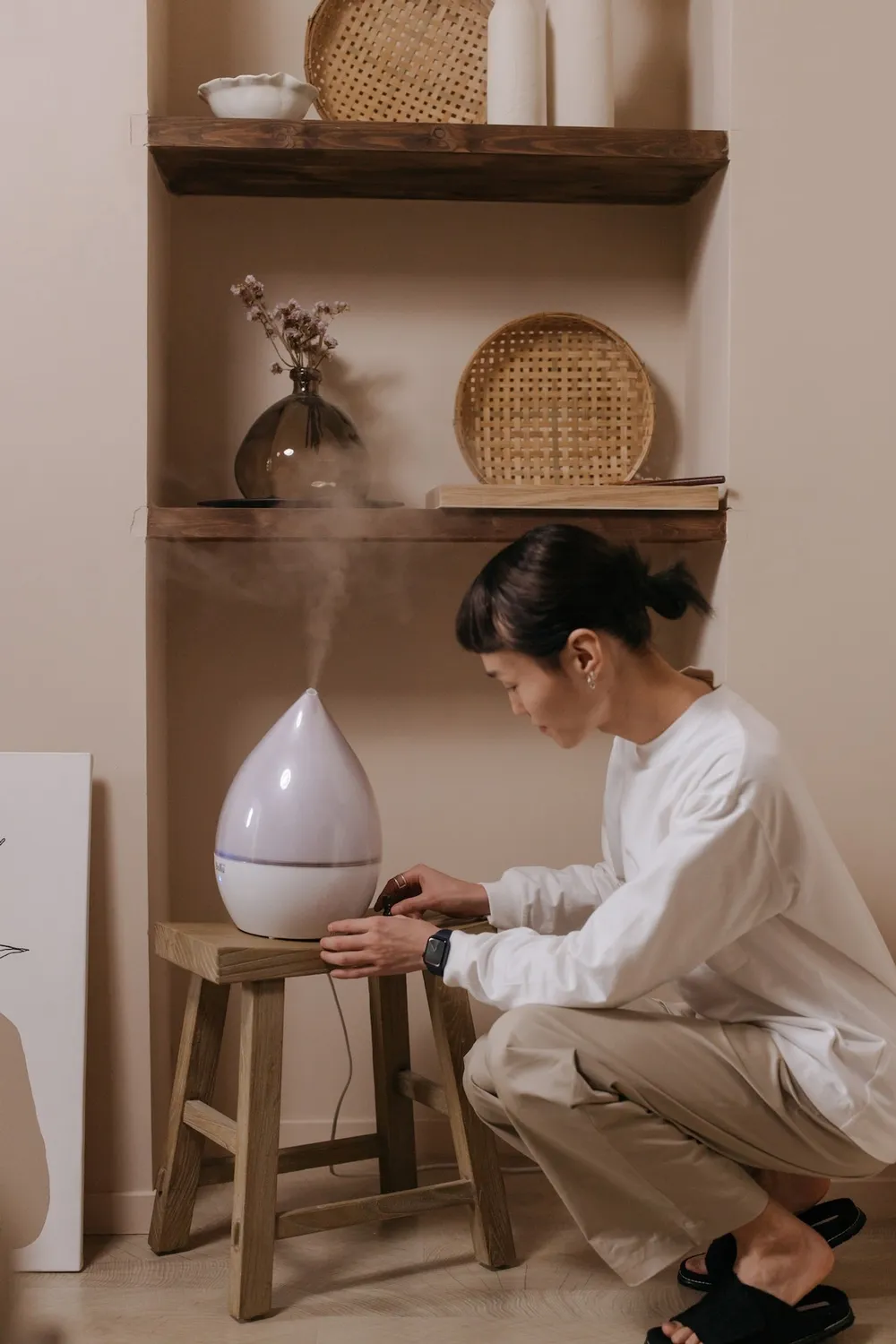 Woman turning on a humidifier. 
