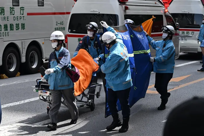A person is taken on a stretcher to an ambulance by paramedics at the Ginza 6 Shopping Center in Tokyo on May 25, 2026, after an individual allegedly sprayed a substance in the area.