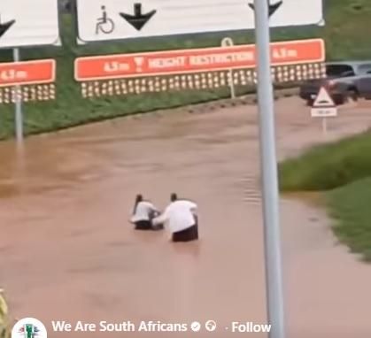 WATCH: Two people brave floodwaters to enter O. R. Tambo International Airport