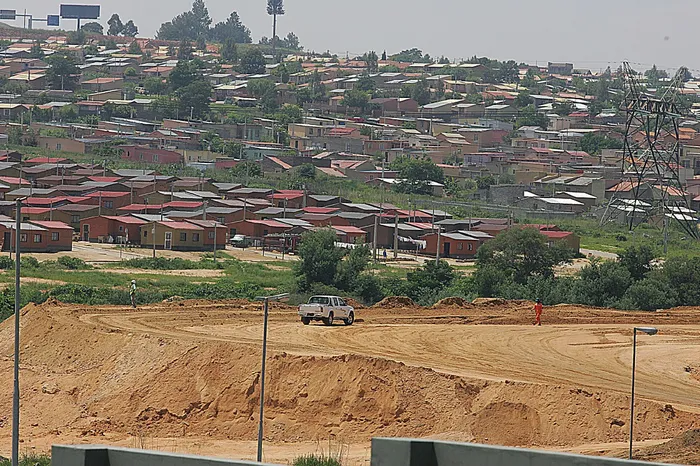 The West bank of alexandra Township looms in the distance as workers make way fo
