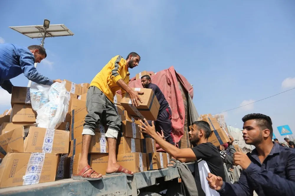 People unload humanitarian aid from a truck at the Rafah crossing in the southern Gaza Strip, on Nov. 2, 2023. Photo by Khaled Omar/Xinhua
