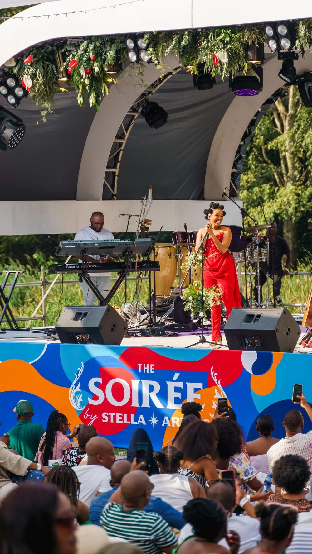 A female musician wearing a red dress performing at a music concert. 