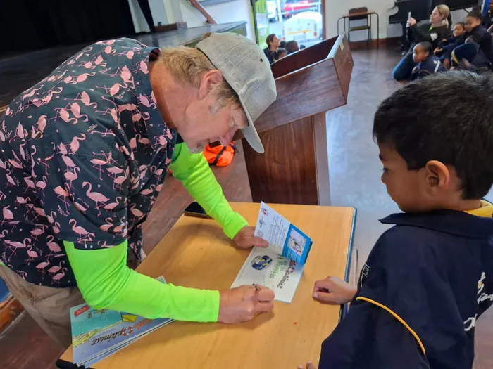 Greg Bertish signing a copy of his book for a fan.