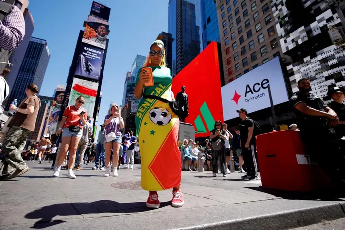 A woman wearing a dress featuring the Senegal flag is pictured in Times Square ahead of the 2026 World Cup football match between France and Senegal in New York City.
