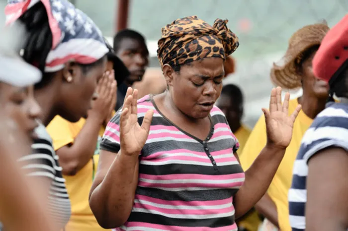 06/02/2015 Family members and friends of the three trapped miner workers pray for their safe return near the entrance of Vantage Goldfields Lily Mine where rescue operations are underway to locate and recover the three missing miners. Picture: Phill Magakoe