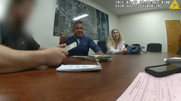 Body camera footage provided by the Riviera Beach Police Department shows Luis Salavar, center, who returned the fanny pack and cash to its owner. 