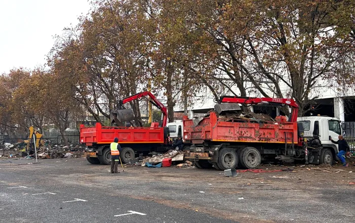 City trucks on the scene clearing up the litter and rubble at the scene.