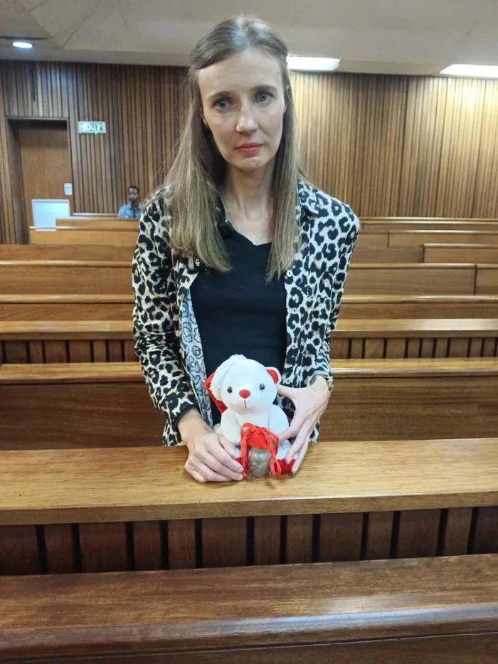 Alysia von Kloeg holding a toy bear containing the ashes of her deceased son Noah.