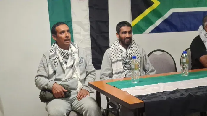 Qutb Hendricks, seated next to Yusuf Rahman, shares his harrowing experience of detention at O.R. Tambo International Airport, recounting the brutal treatment he faced during the Gaza flotilla mission and emphasising the urgent need for global action against oppression.