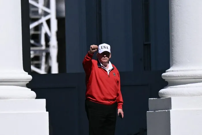 US President Donald Trump raises his fist as he returns to the White House in Washington, DC, after golfing at his Trump National Golf Club in Sterling, Virginia.