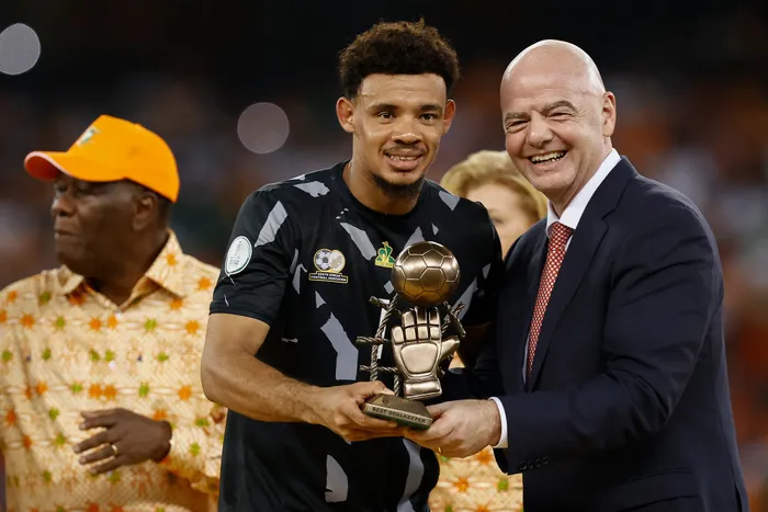 South Africa's goalkeeper Ronwen Williams (C) receives the Golden Glove award from President of FIFA Gianni Infantino (R) during prize giving ceremony following the Africa Cup of Nations (CAN) 2024 final football match between Ivory Coast and Nigeria at Alassane Ouattara Olympic Stadium in Ebimpe, Abidjan