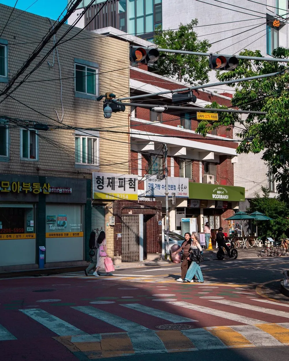 Two young Western-looking tourists stroll a  street past small shops.