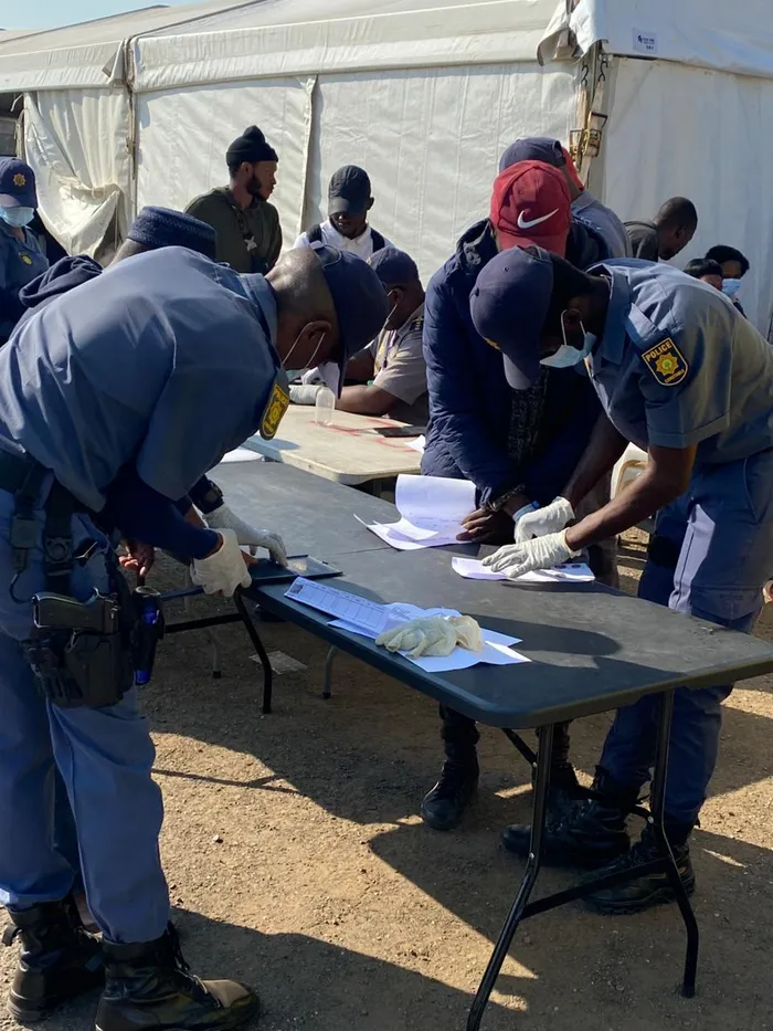 SAPS officers verifying foreign nationals at the Old Drive in, in Durban on Monday. 