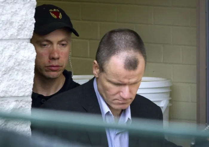 Colonel Russell Williams, front, is escorted from Belleville court after being sentenced to life in prison.