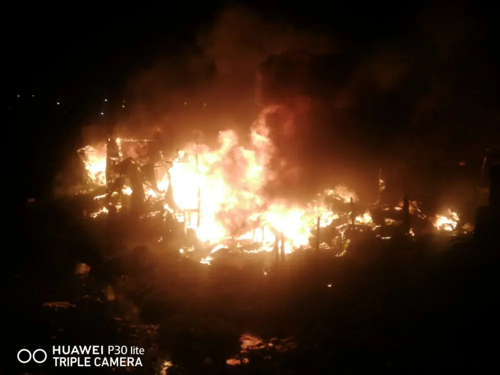 A fire burns up homes at night.