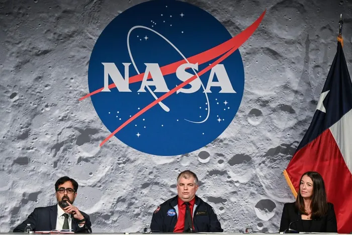 NASA’s Artemis II flight director Jeff Radigan (C), speaks next to Artemis II Vehicle Manager Branelle Rodriguez (R) and NASA’s associate administrator Amit Kshatriya (L), during a status briefing of the Artemis II crewed lunar mission, on April 9, 2026, at the Johnson Space Center in Houston, Texas.