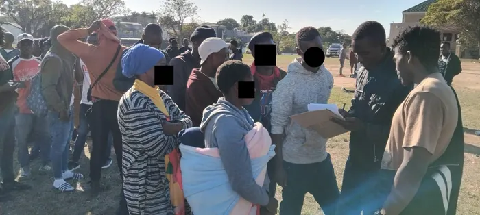 A volunteer from the Malawian community takes down the details of those that fled from the Clare Estate informal settlement in Durban and settled at the Sherwood Hall playground. 