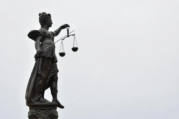 Lady Justice stands weighing and armed, even as the tools are quietly changing hands.