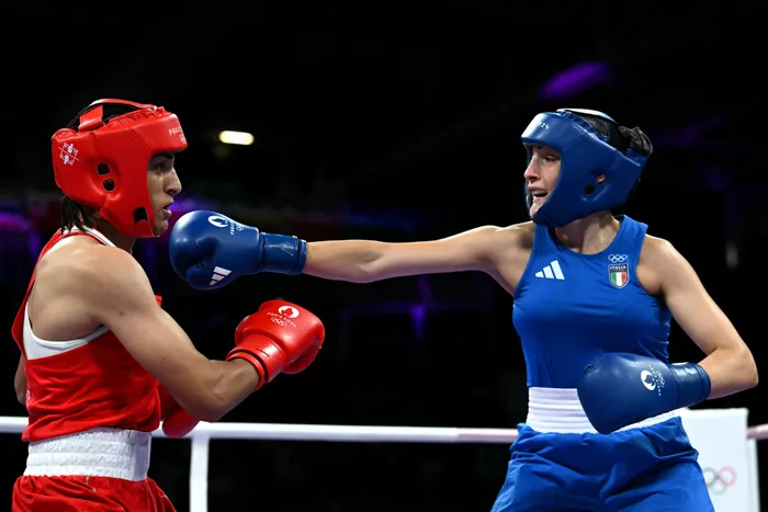 Algeria's Imane Khelif (in red) takes a punch from Italy's Angela Carini in the women's 66kg preliminaries round of 16 boxing match during the Paris 2024 Olympic Games on Thursday
