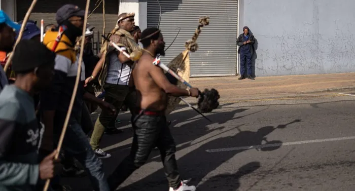 A man looks on as protesters march past him during a protest march against undocumented migrants in Springs, Ekurhuleni on Monday. 