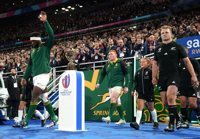 Springbok captain Siya Kolisi (left) and New Zealand captain Sam Cane walk out past the Webb Ellis Cup