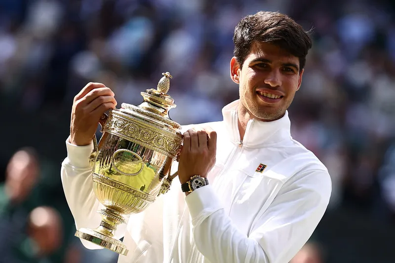 Carlos Alcaraz poses with the winner's trophy after beating Novak Djokovic in the Wimbledon final.