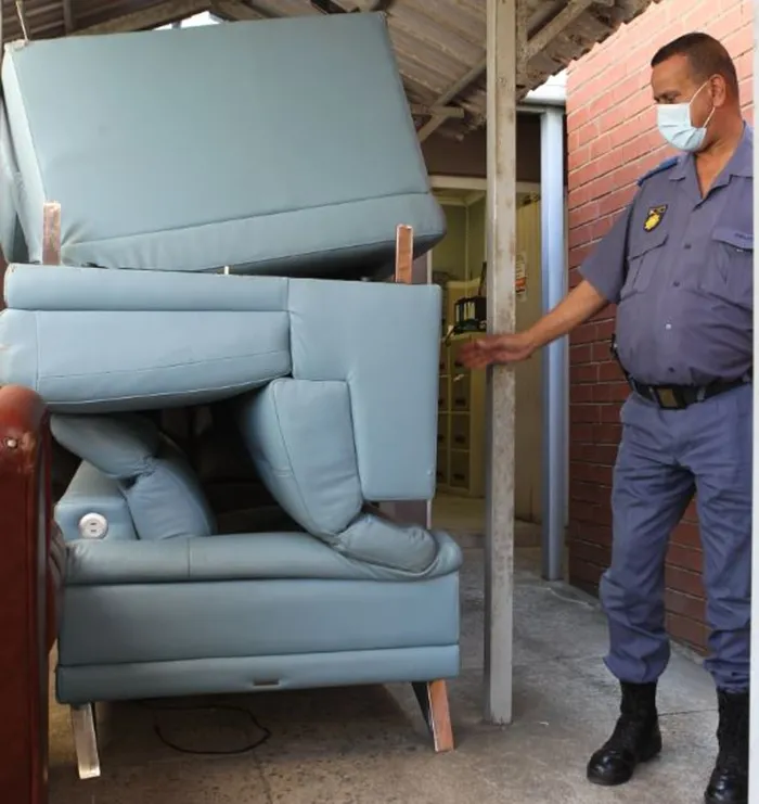 The five-seater leather sofa which was dismembered was recovered by members of the police on Sunday. Seen is Lieutenant-Colonel Gregory Joseph, the vispol commander at Sydenham SAPS. The sofa is being kept, among other looted furniture and goods at the station. Picture: Sibonelo Ngcobo/African News Agency (ANA)
