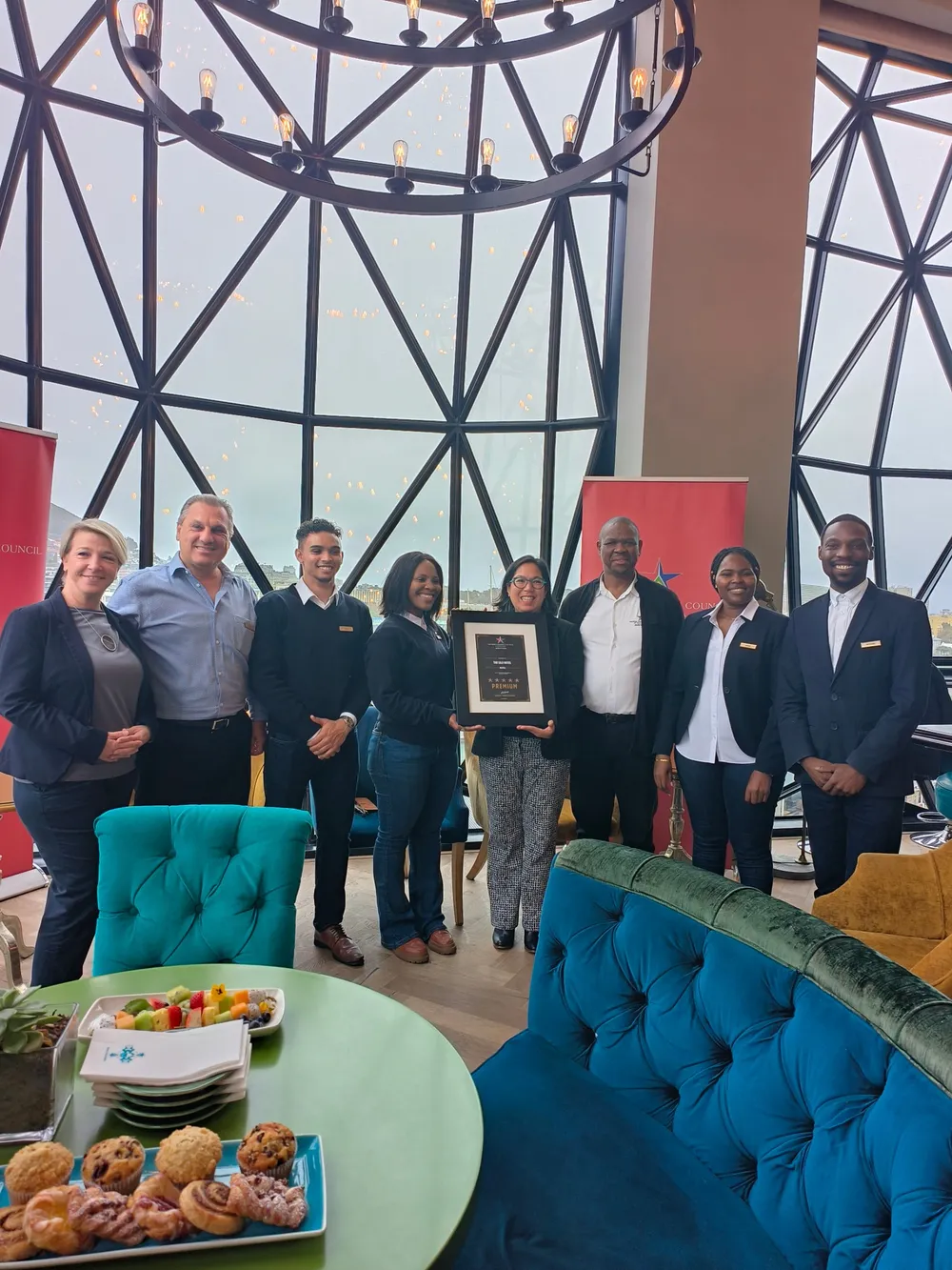 Picture of The Silo management team in a plushly decorated public areas, displaying the certificate.