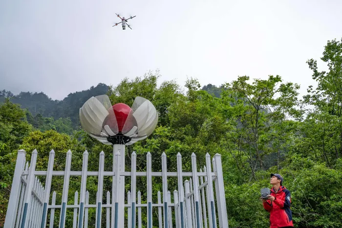 A staff member of a national field observation and research station for forest ecosystem in Dayao Mountain, south China's Guangxi Zhuang autonomous region operates a drone to patrol the forest and collect data.