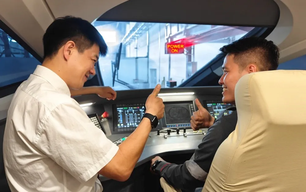 A Chinese instructor interacts with an Indonesian train driver on a train at a maintenance workshop of the Tegalluar Station in Bandung, Indonesia, Aug. 25, 2023. Xinhua/Xu Qin