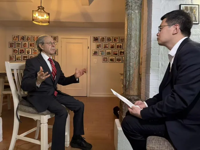 People's Daily journalist Li Zhiwei interviews Robert Lawrence Kuhn (left).