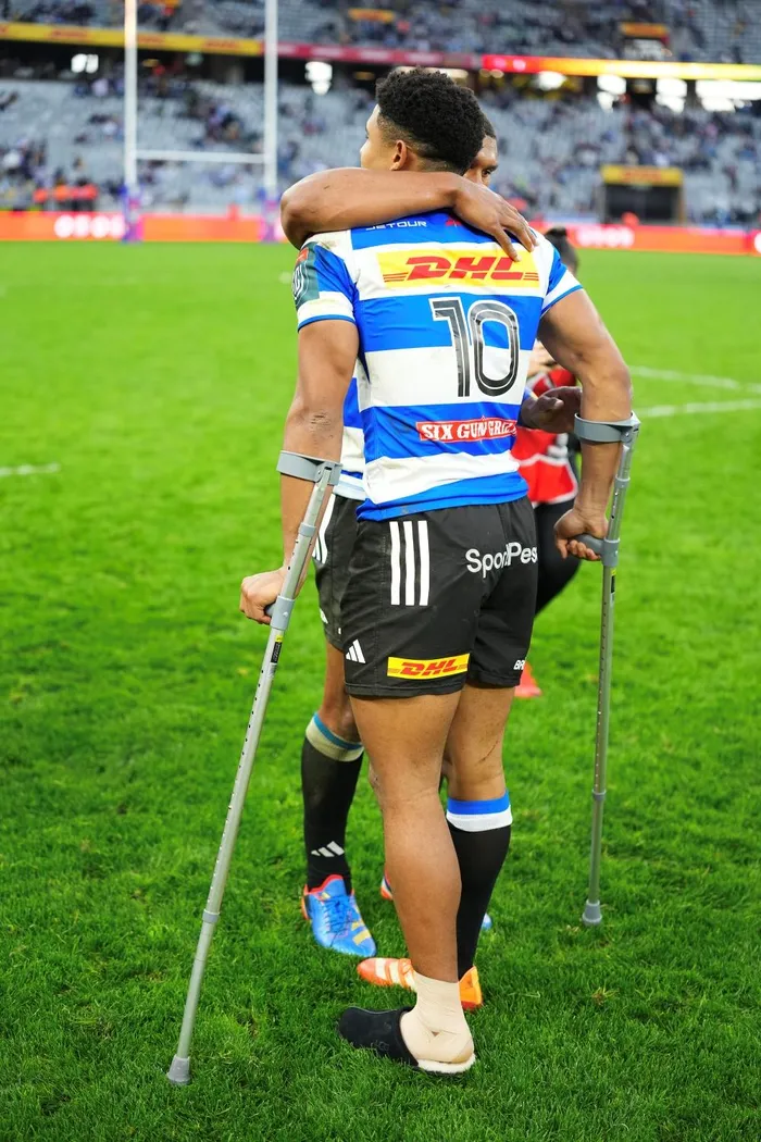 Stormers flyhalf Sacha Feinberg-Mngomezulu is hugged by fullback Damian Willemse following the URC quarter-final against Cardiff in which the No 10 picked up a serious ankle injury.