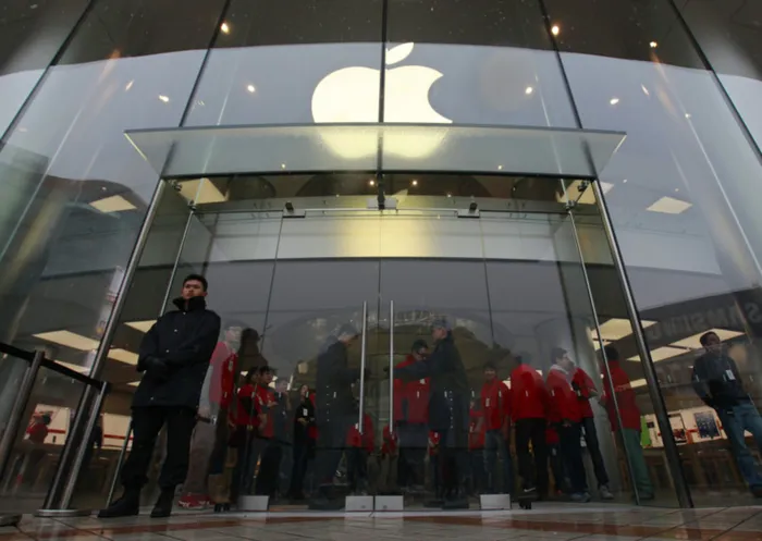 Security guards and staff stand at the entrance of an Apple store during the release of iPhone 5 in Beijing's Wangfujing shopping district, December 14, 2012. The China release of its iPhone 5 on Friday should win Apple Inc some respite from a recent slide in its share of what is likely already the world's biggest smartphone market, but its longer-term hopes may depend on new technology being tested by China's top telecoms carrier. REUTERS/Petar Kujundzic (CHINA - Tags: BUSINESS TELECOMS)