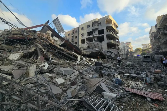 People gather at the site of an Israeli strike that hit near a hospital in the southern Lebanese city of Tyre.