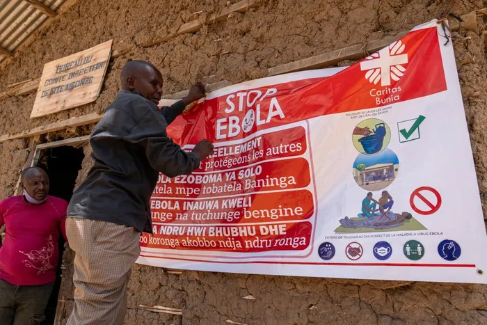 A man hangs an Ebola awareness banner in the Kigonze camp in Bunia, in the eastern Democratic Republic of the Congo, on May 28, 2026.