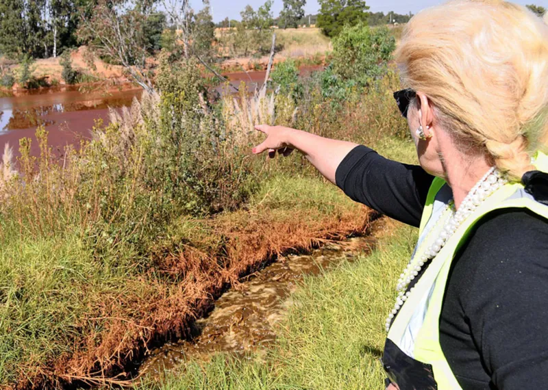 Mariette Liefferink points out a lake that still shows the effect of treated water at the acid mine drainage plant near Krugersdorp say much need to be done to really get the problem under control. Picture: Timothy Bernard/African News Agency/ANA