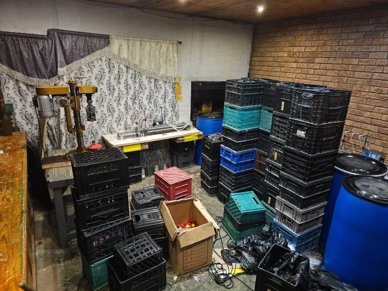 Police uncover illegal alcohol manufacturing plant while searching for unlicensed firearm in Uitzicht