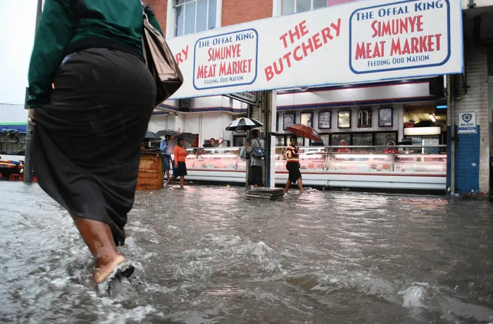 An image of a woman running through a flooded street in Durban