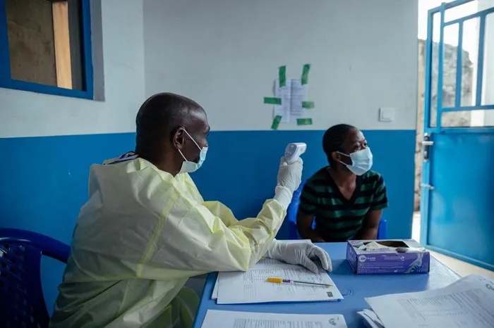 A doctor from CBCA Virunga, following training on Ebola protection measures, works at a checkpoint set up at the hospital entrance as part of Ebola prevention measures in Goma