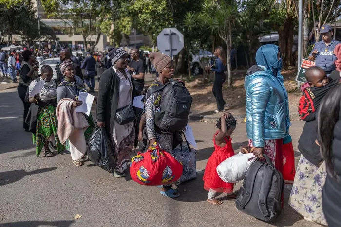 Migrants stand in a queue to board the first of seven buses at the Sherwood Park in Durban to travel back to Malawi.