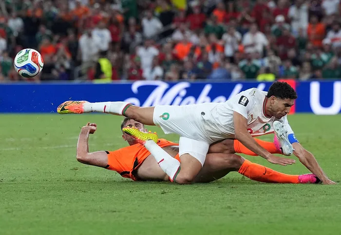 Achraf Hakimi of Morocco is tackled by Netherlands defender Micky van der Ven during their World Cup round-of-32 match.