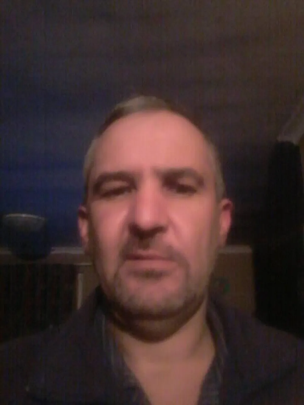 Close-up of a middle-aged man’s face, looking serious.