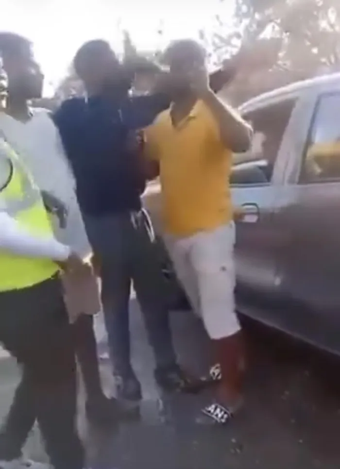In this screenshot, a motorist who tried to confront a pupil who was assaulting people with water was confronted by the pupil and three others, who made threatening gestures at the motorist, forcing him to retreat to his vehicle. 