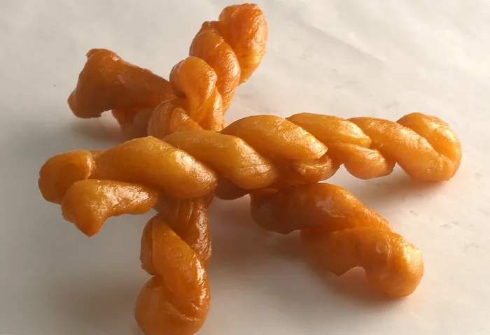 This traditional Afrikaner confection is known for its distinctive braided shape, crisp exterior and sticky, syrup-filled centre.
