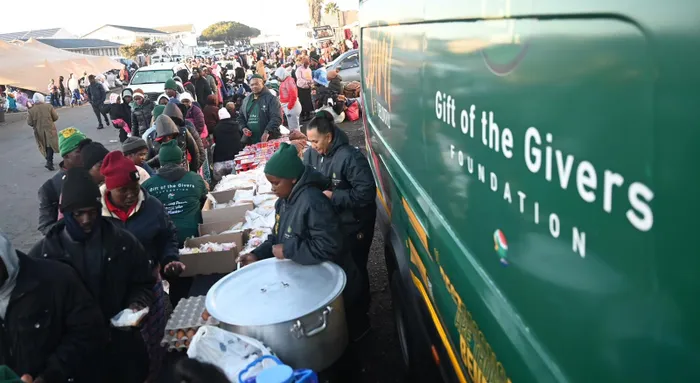 Hundreds of Zimbabwean nationals queue for food at the temporary repatriation centre in Epping, where thousands people waited for transport to return home voluntarily.